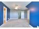 Bright bedroom features blue accent wall, ceiling fan, and neutral carpeting at 259 Hwy 11, Social Circle, GA 30025