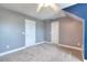 Neutral carpeted bedroom with a tray ceiling, ceiling fan and two doors in a cozy home setting at 259 Hwy 11, Social Circle, GA 30025