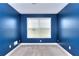 Minimalist bedroom with neutral carpet and navy-painted walls with a sunlit window view at 259 Hwy 11, Social Circle, GA 30025