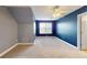 Bedroom featuring carpet and a blue accent wall with a closet and doorway at 259 Hwy 11, Social Circle, GA 30025
