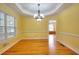 A dining room features bright yellow walls, a decorative chandelier, and hardwood flooring at 259 Hwy 11, Social Circle, GA 30025