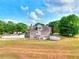 Expansive backyard view of a brick two-story home and green landscape at 259 Hwy 11, Social Circle, GA 30025