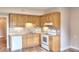 Compact kitchen featuring wooden cabinets, white appliances, and tile backsplash at 259 Hwy 11, Social Circle, GA 30025