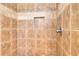 Shower featuring brown tile surround and built-in alcove for soaps and shampoos at 259 Hwy 11, Social Circle, GA 30025
