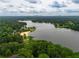 Scenic aerial view of a lake with a sandy beach, surrounded by lush greenery and trees at 4721 W Lakeshore Dr, Acworth, GA 30101