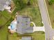 Aerial view of a home with a gray roof, inground pool, well maintained lawn and close proximity to the neighborhood at 4721 W Lakeshore Dr, Acworth, GA 30101
