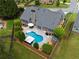 Aerial view of a private backyard featuring a kidney-shaped pool, patio with furniture, and landscaped surroundings at 4721 W Lakeshore Dr, Acworth, GA 30101