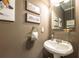 A powder room with a decorative sink, a towel holder, paintings, and a framed mirror at 4721 W Lakeshore Dr, Acworth, GA 30101