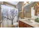 A functional bathroom with a shower, toilet, vanity sink, framed mirror, and decorative shower curtain at 4721 W Lakeshore Dr, Acworth, GA 30101