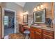 A well-lit bathroom with granite countertops, double vanities, decorative mirrors, and tile flooring at 4721 W Lakeshore Dr, Acworth, GA 30101