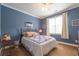 A charming bedroom with neutral walls, carpet, a ceiling fan, and a bed with a white and blue quilt at 4721 W Lakeshore Dr, Acworth, GA 30101