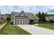 Well-maintained home featuring a two-car garage, long driveway, and manicured lawn at 4721 W Lakeshore Dr, Acworth, GA 30101
