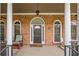 Inviting front porch with brick detailing, rocking chair, and elegant columns with a 'Welcome' mat at the door at 4721 W Lakeshore Dr, Acworth, GA 30101