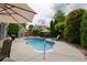 Backyard pool area with a large patio, mature trees, and a lounge chair at 4721 W Lakeshore Dr, Acworth, GA 30101