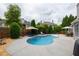 Backyard pool area with a large patio, mature trees, and lounge chairs at 4721 W Lakeshore Dr, Acworth, GA 30101