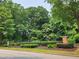 Entrance to the community featuring a black fence and attractive landscaping at 5580 Jamerson Dr, Atlanta, GA 30349
