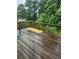Wet wooden deck surrounded by lush greenery and trees at 5580 Jamerson Dr, Atlanta, GA 30349