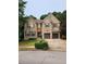 Charming two-story brick home featuring a two-car garage and well-manicured lawn and landscaping at 5580 Jamerson Dr, Atlanta, GA 30349