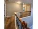 Upstairs hallway with neutral walls and a wooden railing, with clear sightlines to all bedrooms at 5580 Jamerson Dr, Atlanta, GA 30349