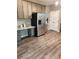 Open kitchen boasts gray cabinets, stainless steel fridge, granite counters, and wood-look floors at 5580 Jamerson Dr, Atlanta, GA 30349