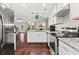 This kitchen features granite counters, stainless appliances, white cabinets and view into the living room at 6330 Garden Cir, Douglasville, GA 30135