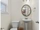 This powder room has a pedestal sink, decorative mirror, and a window with modern blinds at 6330 Garden Cir, Douglasville, GA 30135