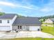 Back exterior view with a concrete patio, lawn, and two-car garage at 6330 Garden Cir, Douglasville, GA 30135