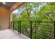 Relaxing balcony with iron railings offers a serene view of the lush, green trees at 112 Rogers Ne St # 304, Atlanta, GA 30317