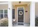 Charming front door with a decorative wreath, columns, and 'hello' door mat at 240 Orchard Dr, Covington, GA 30014