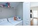 Well-organized laundry room with washer, dryer, and storage shelving at 240 Orchard Dr, Covington, GA 30014