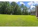 Expansive backyard featuring lush green grass, mature trees, and a convenient storage shed at 3950 Chattahoochee Rd, Cumming, GA 30041