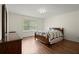 Cozy bedroom with a wooden-framed bed, dresser, neutral walls and wood flooring at 3950 Chattahoochee Rd, Cumming, GA 30041