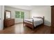 Bright bedroom featuring a wooden framed bed, dresser, a window and wood flooring at 3950 Chattahoochee Rd, Cumming, GA 30041