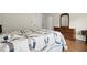 Comfortable bedroom with a cozy, patterned quilt on the bed and a wooden dresser with mirror at 3950 Chattahoochee Rd, Cumming, GA 30041