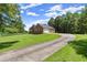 Well-maintained brick home with an attached garage and a long, paved driveway at 3950 Chattahoochee Rd, Cumming, GA 30041