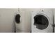 Bright laundry area featuring a large capacity, front load washer and dryer at 3950 Chattahoochee Rd, Cumming, GA 30041