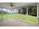Relaxing sunroom with ceiling fan, wood-look floor, and panoramic views of the lush backyard at 3950 Chattahoochee Rd, Cumming, GA 30041