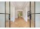 Elegant entryway with herringbone wood floors and steel glass double doors to the house's interior at 4757 Lake Forrest Drive Northwest Dr, Atlanta, GA 30342