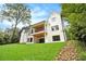 Striking exterior view of the home with a balcony, complemented by a lush green lawn at 4757 Lake Forrest Drive Northwest Dr, Atlanta, GA 30342