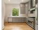 Modern kitchen with stainless steel appliances, grey cabinets, and natural light from the window at 4757 Lake Forrest Drive Northwest Dr, Atlanta, GA 30342
