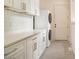 Laundry room with gray tile, white cabinets, counter tops and a stacked washer and dryer at 4757 Lake Forrest Drive Northwest Dr, Atlanta, GA 30342