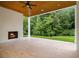 Covered outdoor porch featuring fireplace and ceiling fan overlooking large backyard at 4757 Lake Forrest Drive Northwest Dr, Atlanta, GA 30342