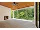 Covered porch featuring a stone fireplace and view of the treed backyard at 4757 Lake Forrest Drive Northwest Dr, Atlanta, GA 30342
