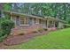 Traditional brick home featuring shutters, covered porch, and manicured landscaping at 4774 Saint Bernard Sw Dr, Lilburn, GA 30047