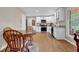 Kitchen with white cabinets, stainless steel appliances, hardwood floors and a dining area at 4774 Saint Bernard Sw Dr, Lilburn, GA 30047