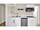 Modern kitchenette with stainless steel appliances, white cabinets, and open shelving at 4774 Saint Bernard Sw Dr, Lilburn, GA 30047