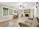 Spacious living area with wood-look floors, brick fireplace, and plenty of natural light at 4774 Saint Bernard Sw Dr, Lilburn, GA 30047
