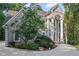 Elegant two-story home featuring a circular driveway, lush landscaping, and impressive columned entrance at 310 Ivy Brooke Ct, Atlanta, GA 30342