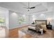 Bright main bedroom features a ceiling fan, windows, and a comfortable bench at the foot of the bed at 310 Ivy Brooke Ct, Atlanta, GA 30342