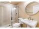 Bathroom with stand up shower and tile surround featuring pedestal sink and large round mirror at 3180 Mathieson Ne Dr # 1401, Atlanta, GA 30305